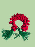 Red crochet heart with green yarn on a white background